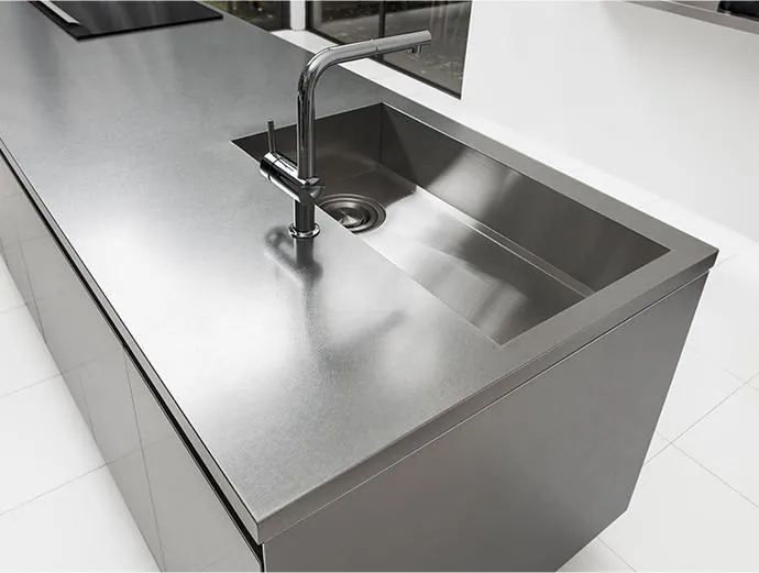 Dark stainless steel modular kitchen with warm under-cabinet lighting